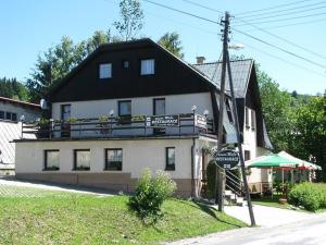 a large white building with a black roof at Penzion Mája Benecko in Benecko