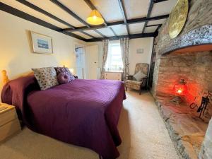 a bedroom with a bed and a stone fireplace at Traditional Cottage with Beautiful Views - Pass the Keys in Isle of Whithorn