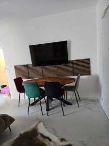 a dining room table with chairs and a flat screen tv at Miliva Apartments in Vir