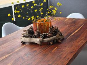 a vase on a table with pine cones and flowers at Miliva Apartments in Vir