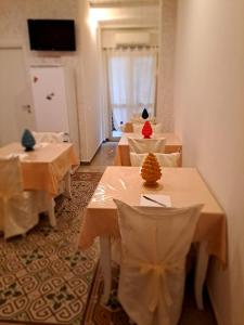 a row of tables in a room with white table cloth at B&B Ammirata in Palermo