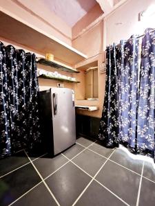 a kitchen with a refrigerator and curtains in a room at Nav Durga Homestay in Udaipur