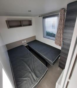 a small room with two beds and a window at Mobil Home Charente-Maritime camping LA PIGNADE in La Tremblade +9 photos
