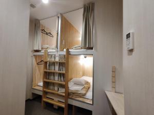 a small room with a bunk bed and a mirror at KOREGA ! Hostel Osaka Namba in Osaka