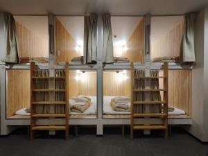 a room with three bunk beds in a room at KOREGA ! Hostel Osaka Namba in Osaka