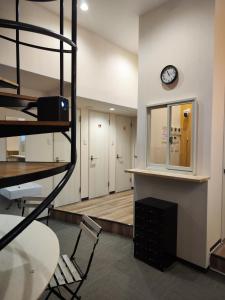 a room with a desk and a clock on a wall at KOREGA ! Hostel Osaka Namba in Osaka
