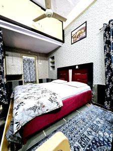 a bedroom with a large bed with a red frame at Nav Durga Homestay in Udaipur