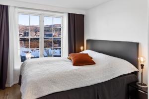 una camera da letto con un letto con una grande finestra di Komfortable Ferieleiligheter med Sjøutsikt a Stadlandet