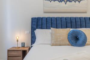 a bed with a blue headboard and a blue pillow on it at Suite Da Vinci in Pavia