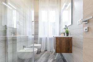 a white bathroom with a sink and a toilet at Suite Da Vinci in Pavia