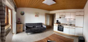 een woonkamer met een stoel en een keuken bij Ferienwohnungen Paukner in Sankt Englmar