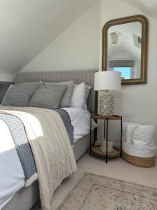 una camera da letto con un letto con uno specchio e una lampada di Stylish Cottage near York a Rawcliffe