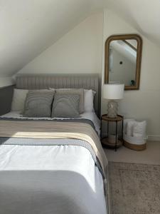 una camera da letto con un letto grande e uno specchio di Stylish Cottage near York a Rawcliffe Altre 18 foto