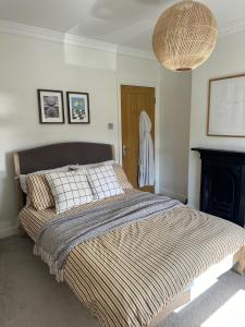 una camera con letto, camino e lampadario a braccio di Stylish Cottage near York a Rawcliffe