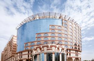 a tall glass building with a curved roof at Pullman Zamzam Madina in Al Madinah