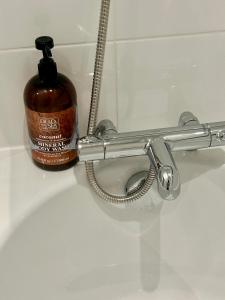 a bottle of soap is sitting next to a toilet at Luxury 2 bedroom apartment in Aberdeen in Kirkton of Skene +51 photos