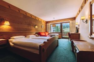 ein Schlafzimmer mit einem großen Bett und einem Fenster in der Unterkunft Hotel Madrisa in Gargellen + 42 Fotos