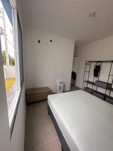 una camera da letto con un letto e una grande finestra di Residencial Terra Mater a Porto Seguro
