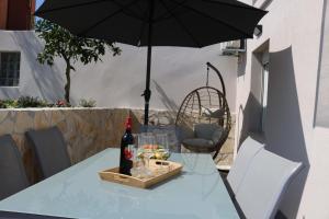 a table with a bottle of wine and an umbrella at Guest House Estela in Vela Luka