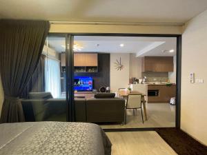 a bedroom with a couch and a living room and a kitchen at La casita hua hin in Hua Hin