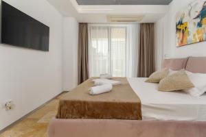 a bedroom with a large bed with a television on the wall at Astria Mediterana - Complex Novum in Olimp