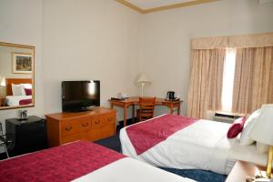 a hotel room with two beds and a flat screen tv at The Glengate Hotel & Suites in Niagara Falls