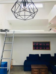 ein Wohnzimmer mit einem blauen Sofa und einem Kronleuchter in der Unterkunft Atelier des lilas in Les Lilas