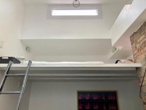 ein Wohnzimmer mit einem Regal und einem Fenster in der Unterkunft Atelier des lilas in Les Lilas