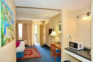 a hotel room with a bed and a microwave at The Glengate Hotel & Suites in Niagara Falls