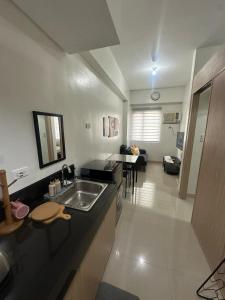 a kitchen with a sink and a living room at Muntinlupa Staycation Leaf Residences in Manila +16 photos