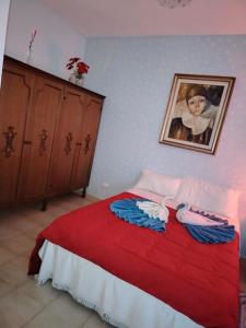 a bedroom with a red bed with a painting on the wall at Casa di Francesca in Ruvo del Monte