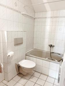 a bathroom with a toilet and a bath tub at Ferienwohnung KÖÖK I - echter Inselblick in Neuharlingersiel +8 photos