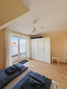 a bedroom with a large bed and a large window at Ferienwohnung KÖÖK I - echter Inselblick in Neuharlingersiel