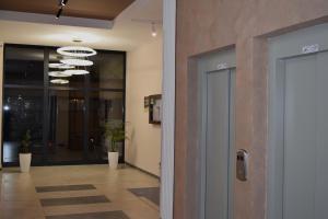 an office lobby with a door and a hallway with plants at Skandik Luxe Residence in Jagodina