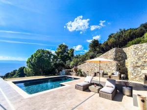 una piscina con dos sillas y una sombrilla en Villa Fanari, en Kanapitsa