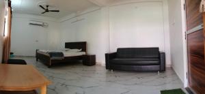 a living room with a couch and a bed at Hotel Mohan Kunj in Ayodhya