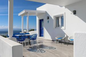 Casa blanca con sillas azules y balcón en Villa Fanari, en Kanapitsa