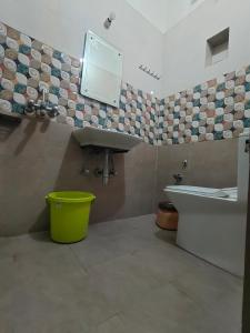 a bathroom with a sink and a tub and a mirror at Hotel Mohan Kunj in Ayodhya