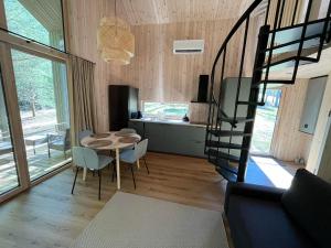 a living room with a spiral staircase and a table and chairs at Gilužio sodyba in Girsteitiškis