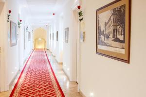 a hallway with a red carpet on the floor at Hotel Kristály Imperial in Tata