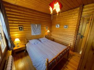 a bedroom with a bed in a log cabin at Charmant Chalet avec Cheminée et Terrasse aux Angles - FR-1-593-128 in Les Angles