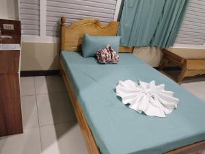 a blue bed with two pillows on it at Ahava Lodge in Cervantes