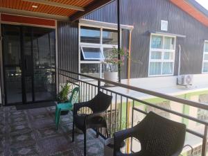 a balcony with two chairs and a table at Ahava Lodge in Cervantes