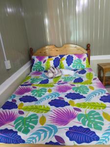 a bed with a colorful comforter and pillows at Ahava Lodge in Cervantes