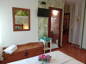 a room with a bed and a table with flowers at Hospedaje Oreña in Oreña