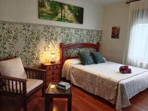a bedroom with a bed and a chair at Hospedaje Oreña in Oreña