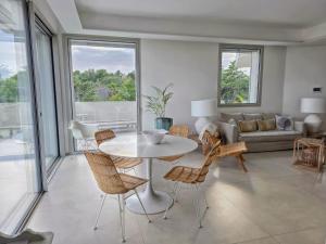 a living room with a white table and chairs at Shati Luxury - New, Heated Pool, Sea view Near beach in Fontane Bianche