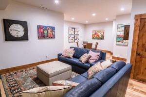 a living room with a blue couch and a clock at Mountain Lodge Oasis w Hot Tub-Rio Grande Trail in Carbondale +39 photos