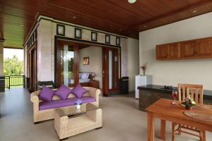 sala de estar con sofá púrpura y mesa en Dewi Sri Private Villa en Ubud