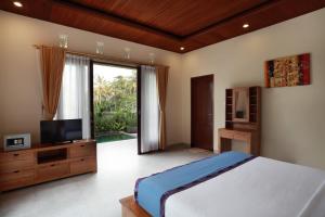 En eller flere senge i et værelse på Dewi Sri Private Villa